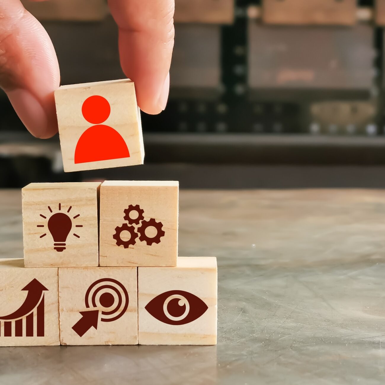 Leadership quality concept. Wooden cubes with icons and hand.